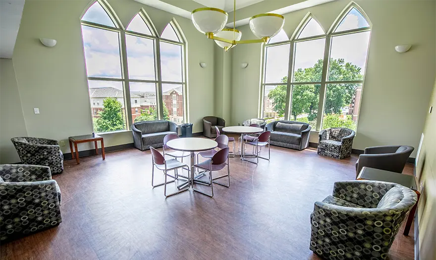 Blount Hall Common Room with tables, chairs, and floor-to-ceiling windows