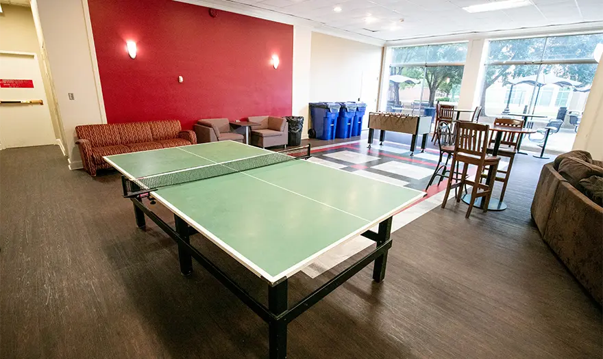 Mary Burke Hall common space with a ping pong table, table and chairs, and couches