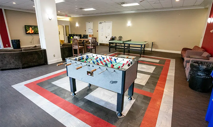 Mary Burke Hall common space with ping pong table, table and chairs, and couches