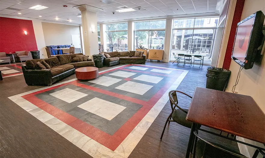 Mary Burke Hall common space with sectionals and a tv