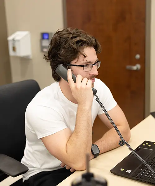 Residence hall desk assistant answering the phone