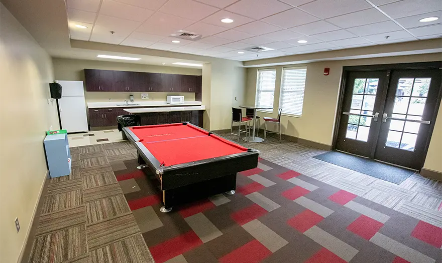 Presidential Village I community room with a ping pong table and community kitchen