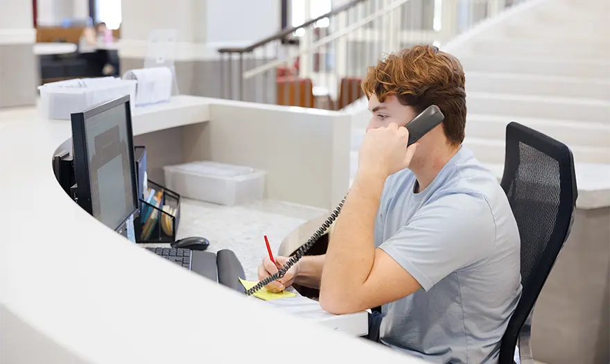 Area desk assistant talking on phone